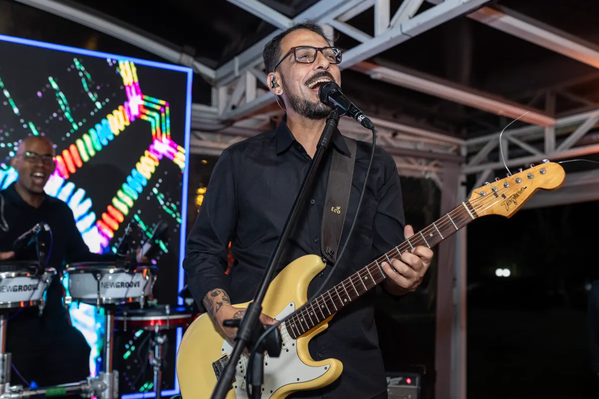 Guitarrista da Baile da Show tocando com o telão ao fundo