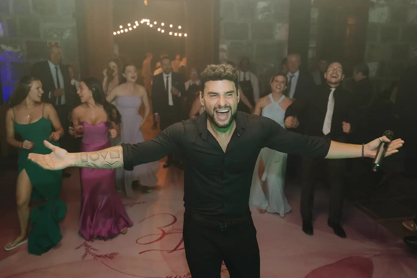 Kadu cantando no meio da pista com os convidados dançando