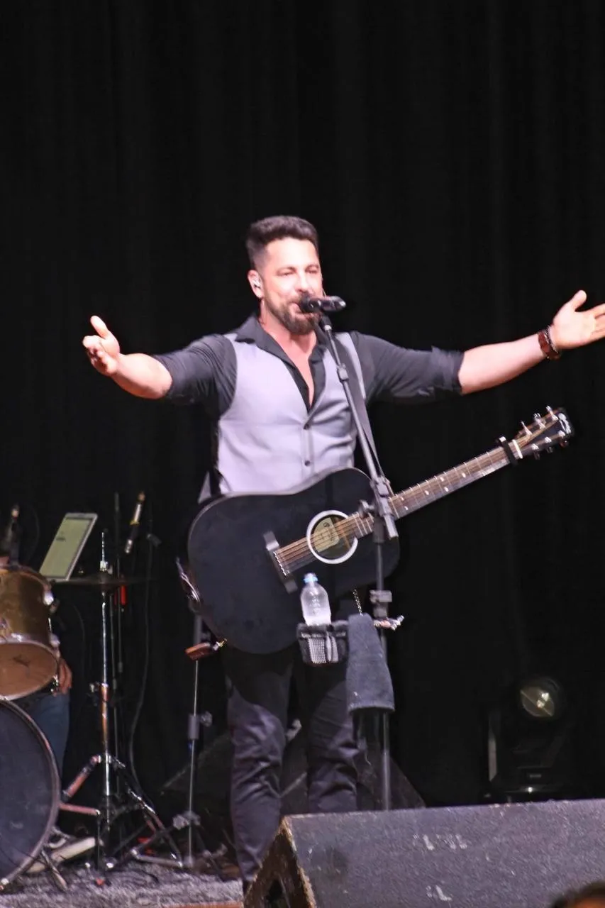 Dani Vendramini de braços abertos no palco