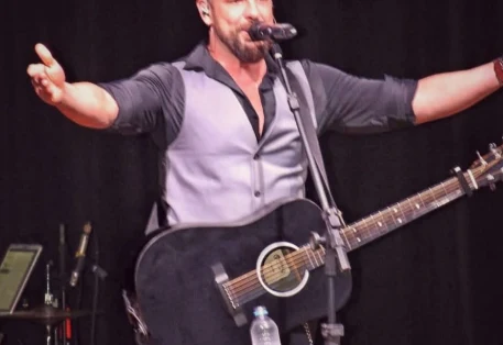 Dani Vendramini cantando com violão no palco