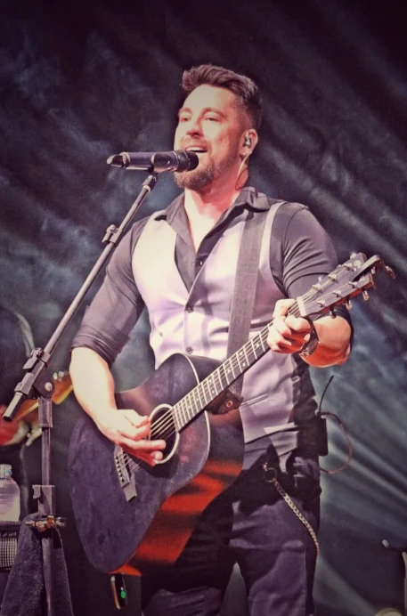 Dani Vendramini cantando e tocando violão