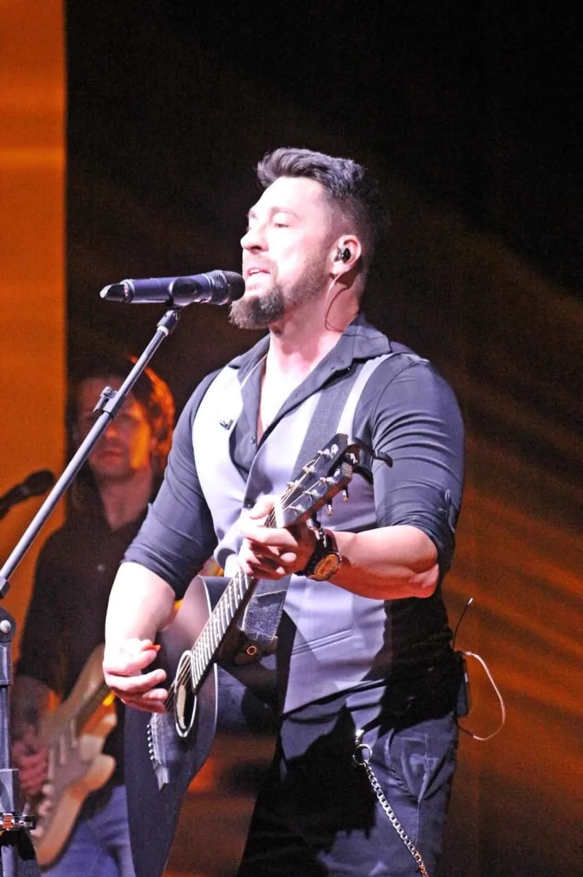 Dani Vendramini cantando e tocando violão
