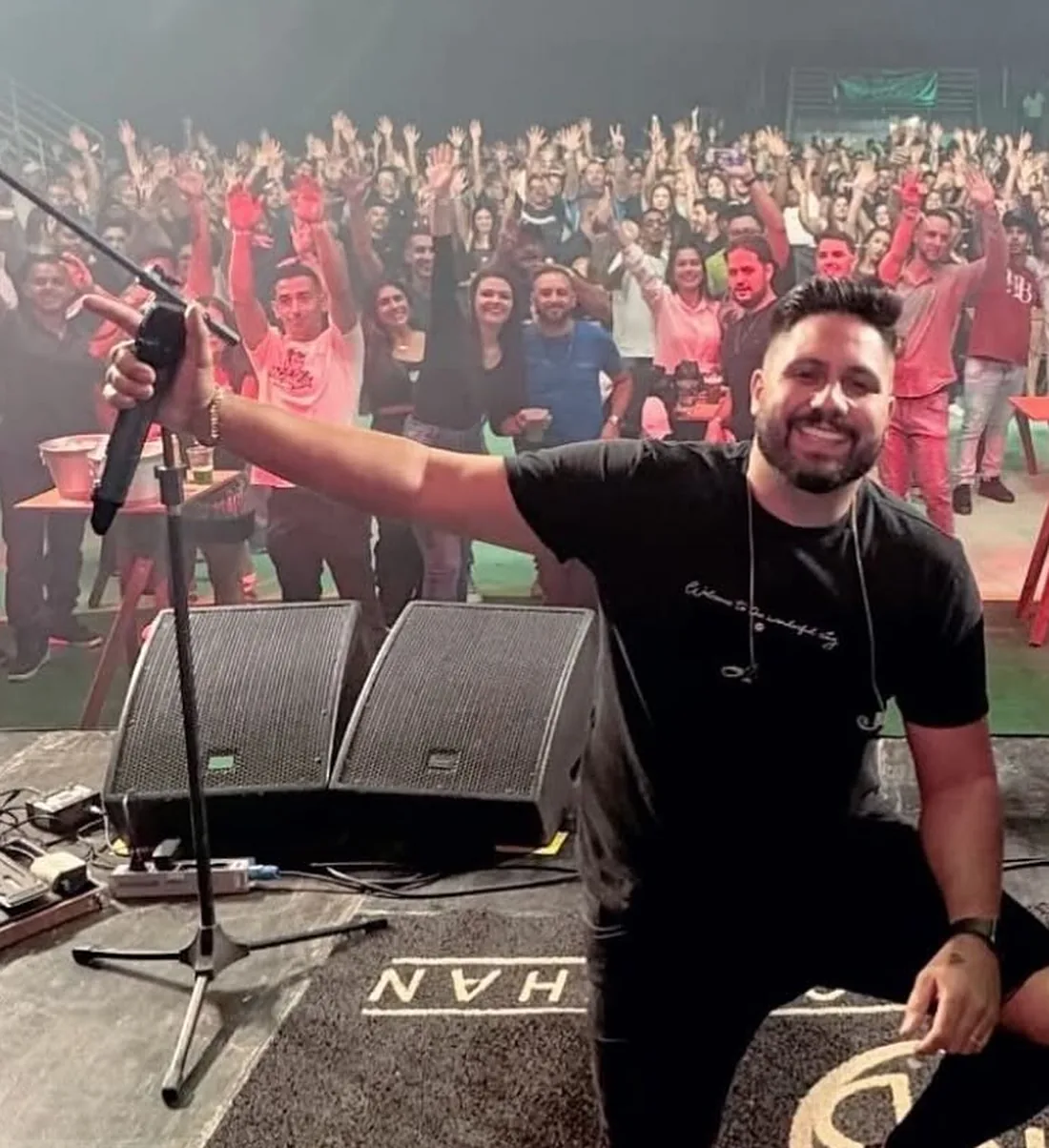 Dion Rodrigues no palco com o público ao fundo